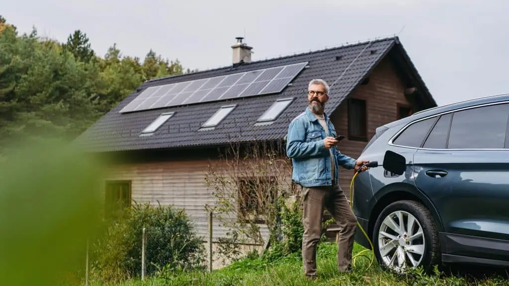 Hausbesitzer vor seinem Haus mit Photovoltaikanlage auf dem Dach – Solarstrom an Nachbarn verkaufen ab Juni 2026