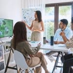 Frau präsentiert Marketing-Strategie für nachhaltige Energielösungen in einem Meeting.