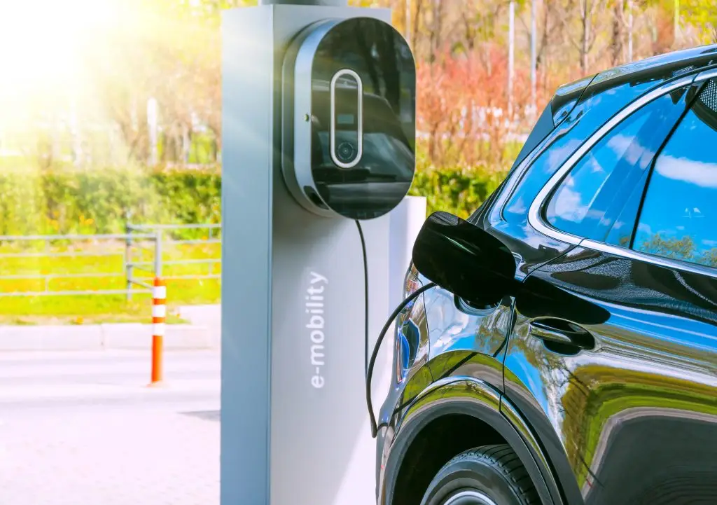 Ladesäule auf einem Firmenparkplatz mit angeschlossenem Elektroauto