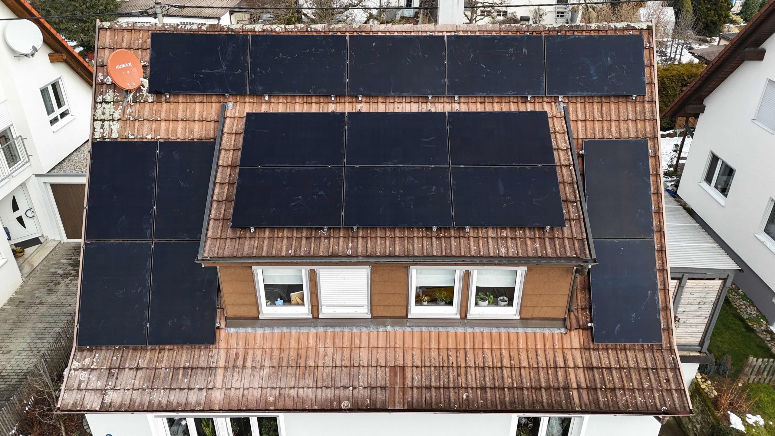 Einfamilienhaus in Nürtingen mit neu installierter 10,93 kWp Photovoltaikanlage auf drei Dachflächen, davor das Montage-Fahrzeug von HUMMEL energize