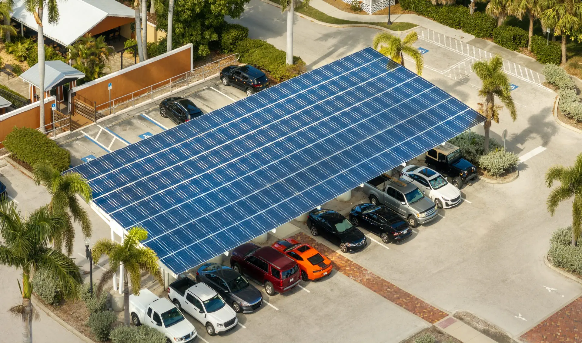 Moderner Solarcarport mit Photovoltaikmodulen auf dem Dach und ladendem Elektroauto – Solarstrom selbst erzeugen und parken