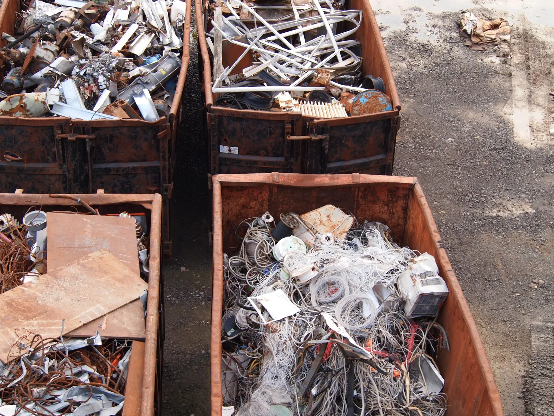 Container auf einem Recyclinghof mit sortenrein getrennten Fraktionen: Aluminiumprofile, Kabel mit Kupfer und Metallschrott